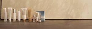 Gamme de produits de soin SENSAI conçus pour limiter l'impact sur l'environnement sur une surface beige sur fond neutre